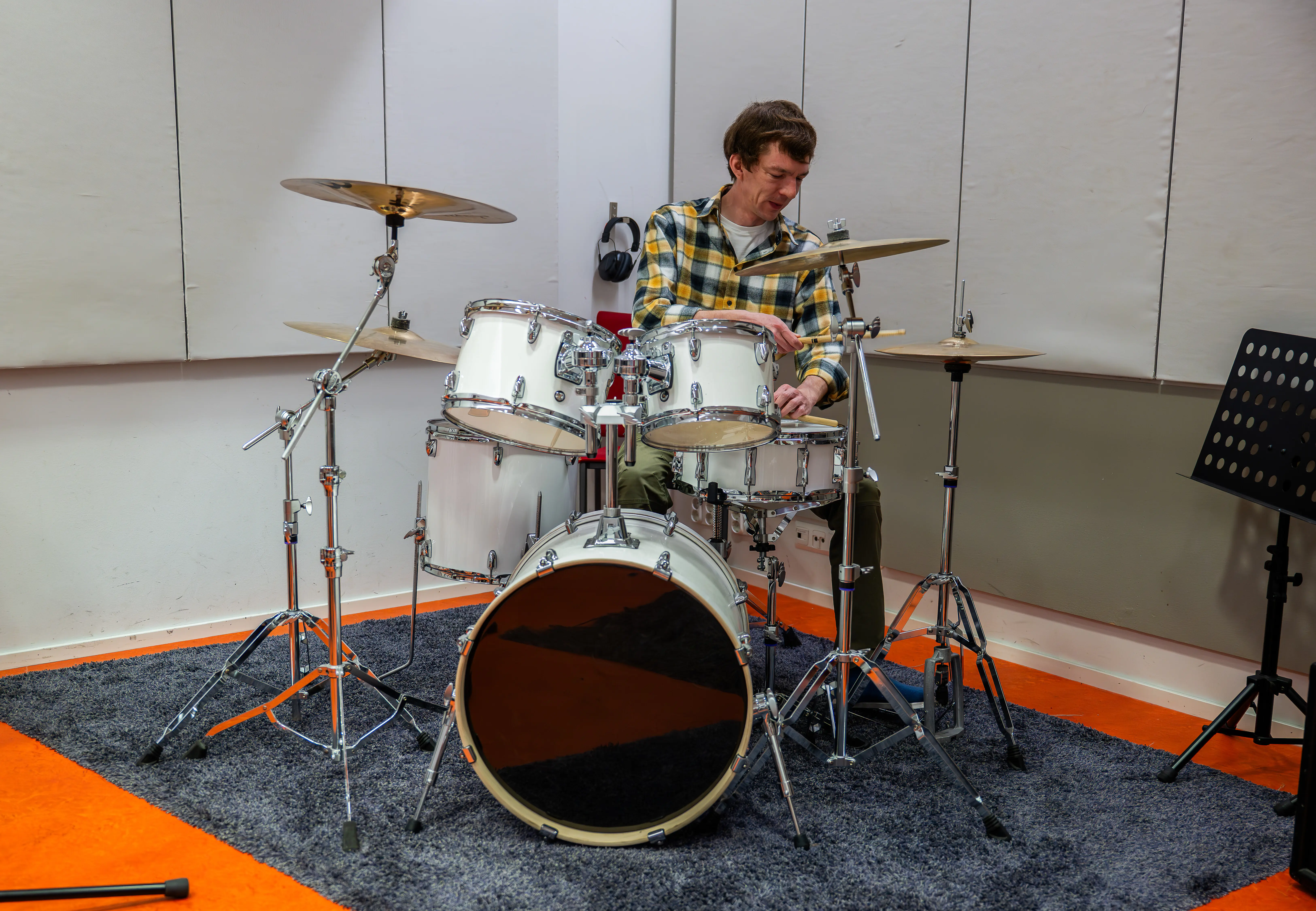 Ein Mann spielt Schlagzeug in einem schalldichten Studio.